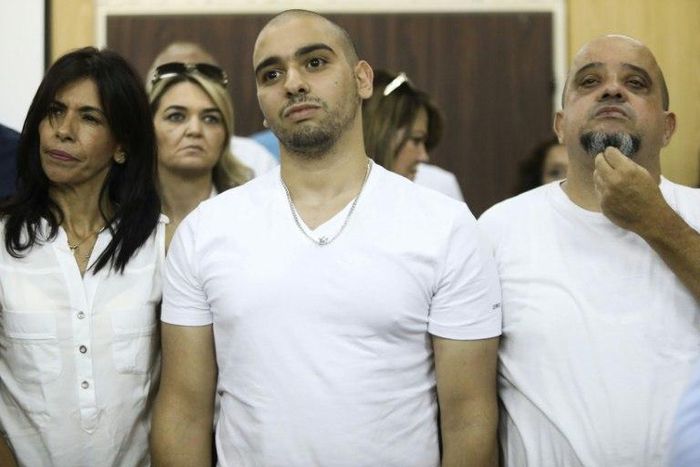 Israeli soldier Elor Azaria, who shot dead a wounded Palestinian assailant in March 2016, stands between his mother Oshra and father Charlie at a military court in Tel Aviv, on July 30, 2017