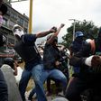 Demonstrators in Caracas hurl rocks at police during Venezuela's nationwide strike on Thursday
