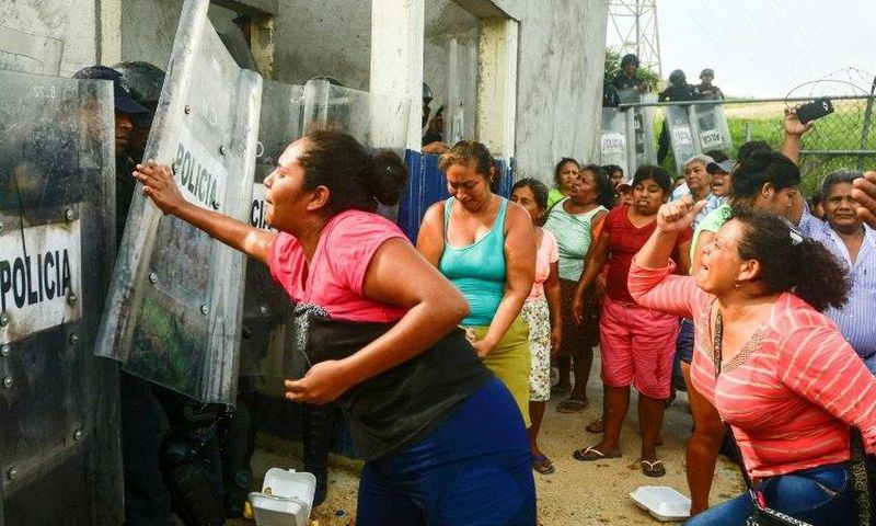 Relatives of inmates struggle with riot police outside Las Cruces prison in Acapulco, following a riot in the facility that left 28 dead and three wounded
