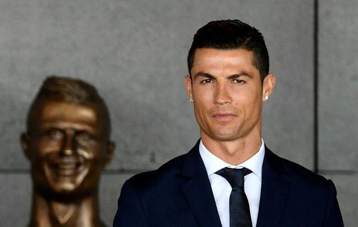 Portuguese footballer Cristiano Ronaldo stands past a bust presented during a ceremony where Madeira's airport in Funchal is to be renamed after Cristiano Ronaldo, on Madeira island, on March 29, 2017