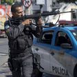 A militarized police officer aims his assault rifle during a search and capture operation at the Mangueira shanty town in Rio de Janeiro, after a policeman there was shot dead