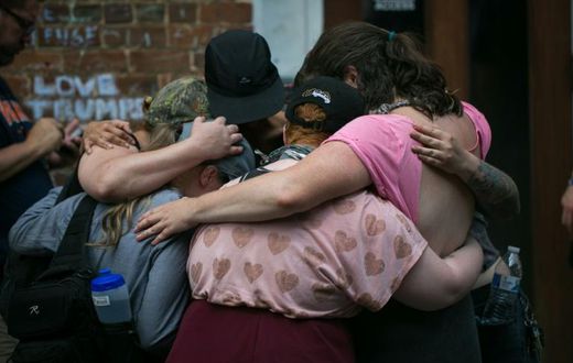 Mourners embrace next to a makeshift memorial to Heather Heyer in Charlottesville, Virginia, on the one year anniversary of her death at the hands of a white supremacist in a speeding car