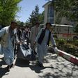 Afghan volunteers carry the body of a Kabul resident killed in a car bomb attack in May