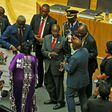 Zimbabwe's President Robert Mugabe, center, gives a $1 million cheque to the African Union during a summit meeting in Addis Ababa, Ethiopia