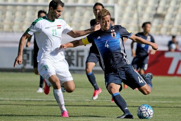 Keisuke Honda (R) of Japan fights for the ball against Iraqi Saad Abdulameer (L) during their 2018 World Cup qualifying football match June 13, 2017