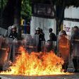 Members of Venezuela's National Guard use their shields to form a barrier from a fire during clashes with anti-government demonstrators in Caracas
