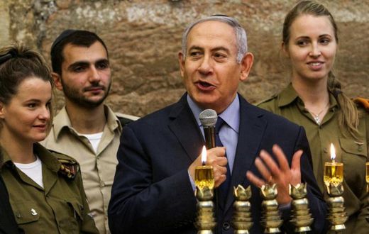 Israeli Prime Minister Benjamin Netanyahu, seen here during a menorah-lighting ceremony with Israeli soldiers for Hanukkah, has hailed majority backing at the UN for condemning militant group Hamas even though a US draft resolution failed to pass