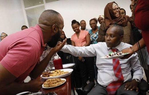Joho's Communications Director, Richard Chacha giving his boss a cake during his birthday