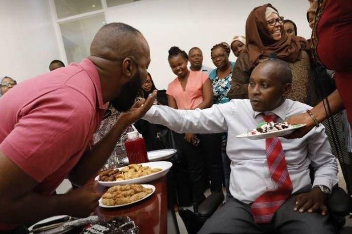 Joho's Communications Director, Richard Chacha giving his boss a cake during his birthday