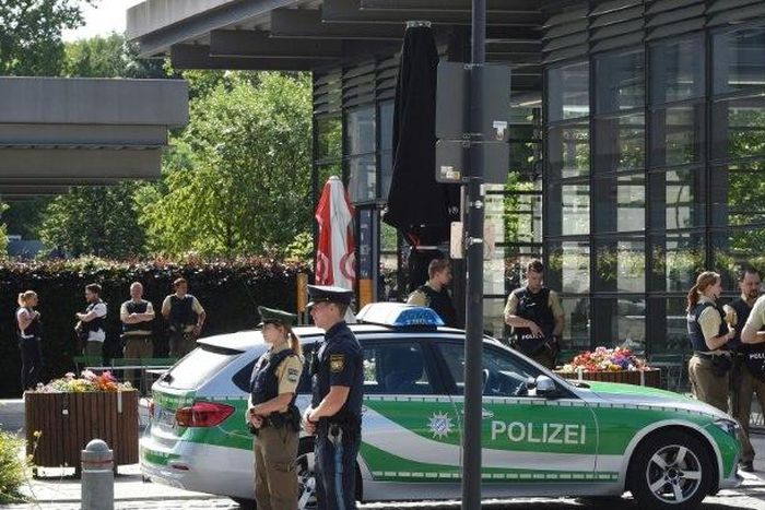 Police secure the area around a rail station near Munich where shots were fired. A female police officer was badly injured and several people were wounded