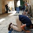 A Palestinian Muslim prays in front of a gate to the Al-Aqsa mosque compound in the Old City of Jerusalem on July 26, 2017, as a tense standoff simmers over the holy site