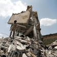 A Yemeni soldier stands on the debris of a house hit in an air strike on a residential district in the capital Sanaa, on August 26, 2017