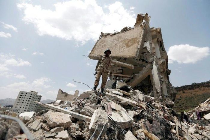 A Yemeni soldier stands on the debris of a house hit in an air strike on a residential district in the capital Sanaa, on August 26, 2017
