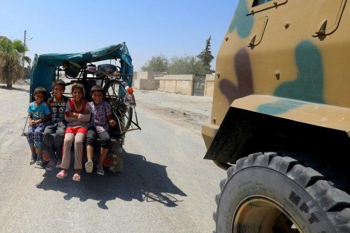 Displaced Syrian children ride in the back of a vehicle in Raqa's western al-Sabahiya district where they are taking shelter