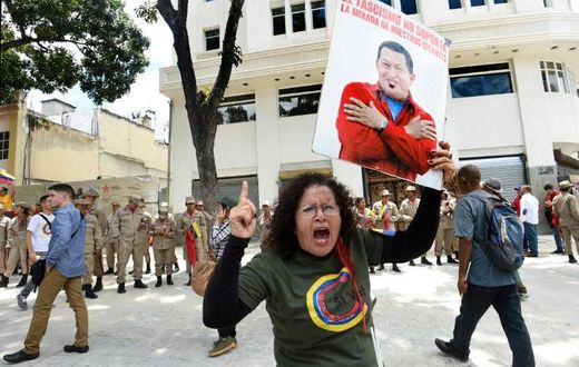 A government supporter holding a picture of late Venezuelan leader Hugo Chavez shouts slogans in favor of the new Constituent Assembly, which began work on Friday
