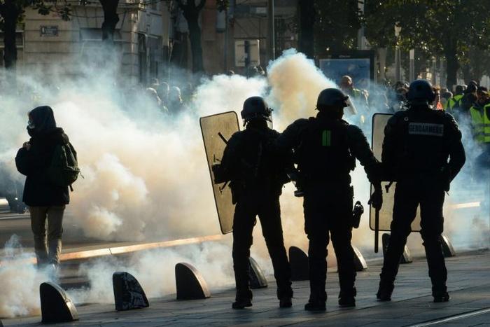 Clouds of tear gas fill the street during a "yellow vest" demonstration in the western French city of Nantes