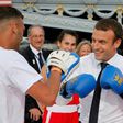 French President Emmanuel Macron (R) spars with a boxing partner on a barge floating on the river Seine in Paris in a bid to promote the candidacy of the city of Paris for the Summer Olympics Games in 2024