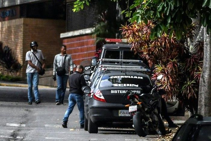 Venezuelan intelligence service members stand guard outside the home of ousted attorney general Luisa Ortega, who says it was raided and searched