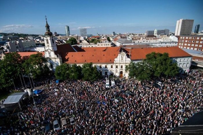 Demonstrators hold up flags of Slovakia and EU during an anti-corruption rally in Bratislava on June 5, 2017