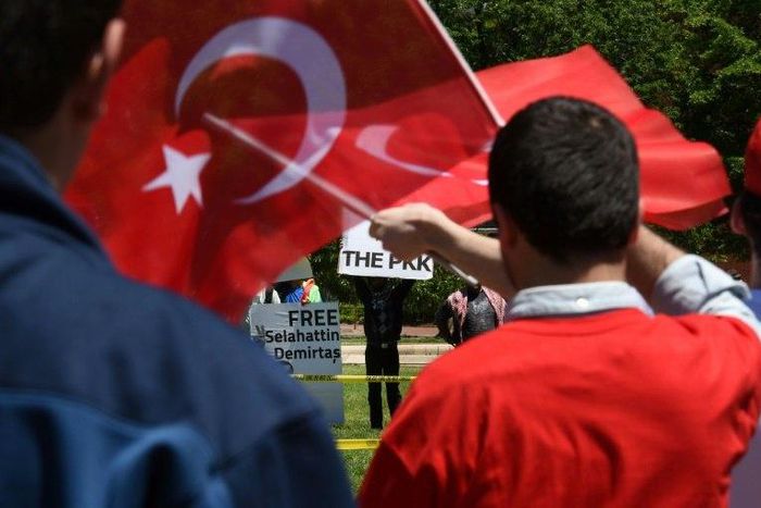 Pro-Erdogan supporters wave Turkish flags at anti-government protesters in front of the White House in Washington, DC on May 16, 2017