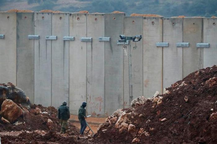 Israeli soldiers stand bye the concrete barrier erected along the border with Lebanon near the northern Israeli town of Metula: a Un investigation said two tunnels dug by Hezbollah stretched beneath the border line and into Israeli territory