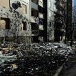Pedestrians walk past a damaged building in Donetsk
