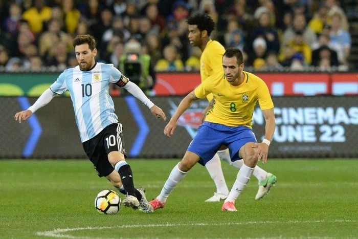 Argentina’s Lionel Messi (L) fights for the ball with Brazil’s Renato Augusto (R) during their friendly international football match between Brazil and Argentina at the MCG in Melbourne