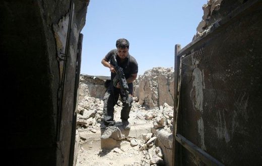 A member of the Iraqi Counter-Terrorism Service secures a building in the old quarter of Mosul, which a coalition general says will be free of Islamic State group fighters by next week