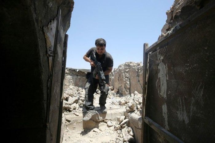 A member of the Iraqi Counter-Terrorism Service secures a building in the old quarter of Mosul, which a coalition general says will be free of Islamic State group fighters by next week