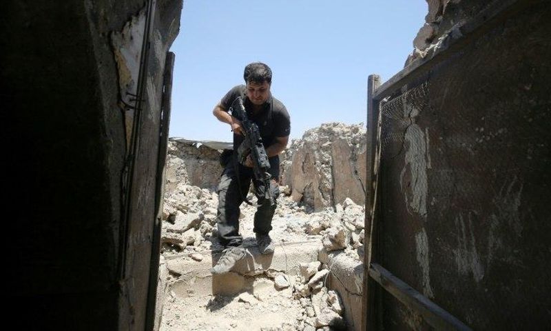 A member of the Iraqi Counter-Terrorism Service secures a building in the old quarter of Mosul, which a coalition general says will be free of Islamic State group fighters by next week