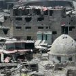 A picture taken on July 9, 2017 shows an Iraqi flag flying from the top of the dome of a badly damaged building