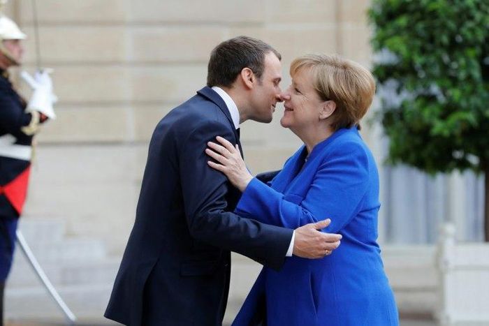 German Chancellor Angela Merkel is welcomed by French President Emmanuel Macron upon her arrival