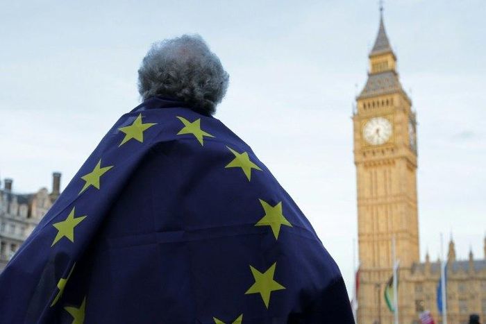 A protester draped in a European Union flag demonstrates outside the Houses of Parliament in London on March 13, 2017