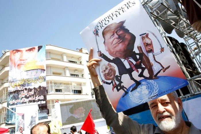 An Iranian man holds a poster bearing images of Israeli Prime Minister Benjamin Netanyahu, US President Donald Trump and Saudi King Salman during a parade. Trump had described a 2015 nuclear accord with Iran as "the worst deal ever" and accused Iran of...