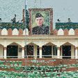 The portrait of Muhammad Ali Jinnah is seen at the India-Pakistan Wagah border post as a Pakistani Ranger (top) unfurls the national flag on Independence Day