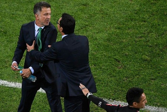 Mexico's coach Juan Carlos Osorio (L) is held back during a 2017 Confederations Cup football match between Mexico and New Zealand at the Fisht Stadium in Sochi, after Osorio lost his temper during an argument with a New Zealand assistant coach