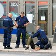Police officers detain the Moroccan suspect who was shot in the leg, in the Finnish city of Turku after a stabbing spree that left two people dead.