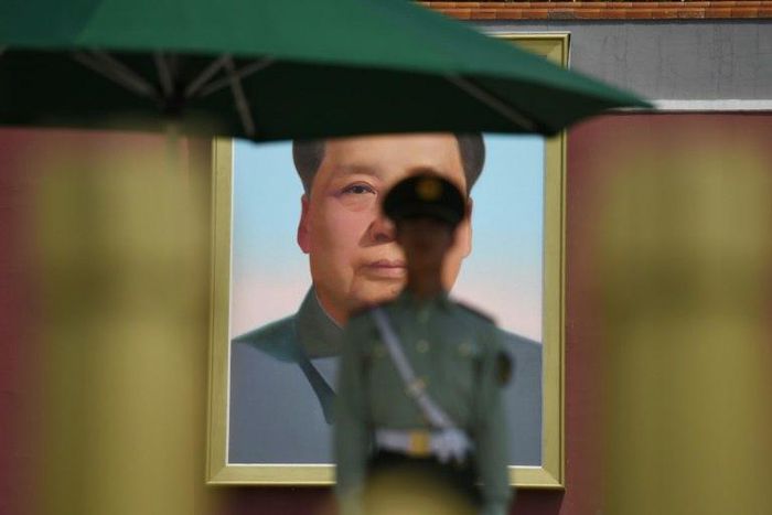 A paramilitary police officer stands guard in front of the portrait of Mao Zedong in Tiananmen Square. Flamboyant real estate tycoon Guo Wengui is waging a one-man guerrilla war against China's elite with explosive accusations of corruption