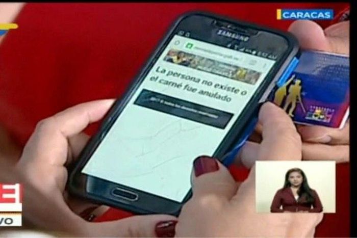 TV grab from Venezolana de Television (VTV) showing the scan result while President Nicolas Maduro holds his IS card, saying "This person does not exist or the ID was canceled."