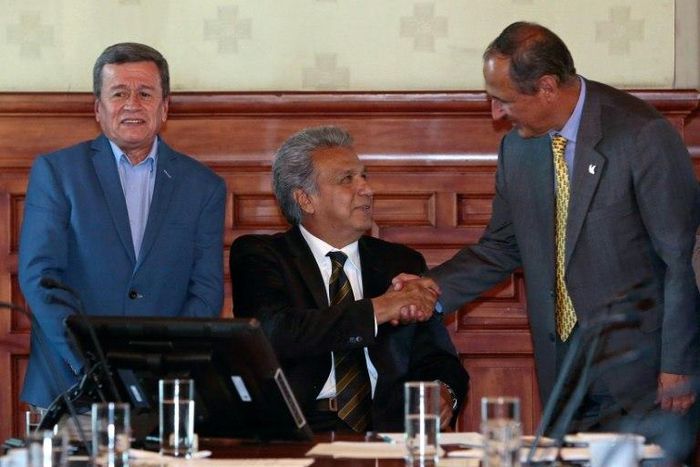 Colombia's government chief negotiator Juan Camilo Restrepo (R) shakes hands with Ecuador's President Lenin Moreno (C) as the National Liberation Army rebel group's chief negotiator, Pablo Beltran, looks on in Quito on August 28, 2017
