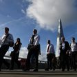 Commuters walk across London Bridge, backdropped by The Shard, in London on June 5, 2017