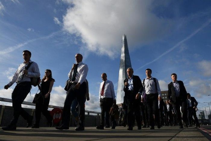Commuters walk across London Bridge, backdropped by The Shard, in London on June 5, 2017