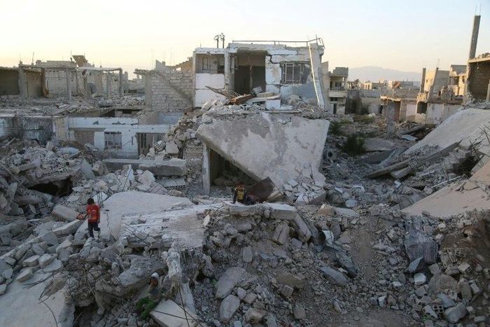 Syrian children play amidst the debris of buildings in the rebel-held town of al-Nashabiyah in the Eastern Ghouta region