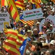 People wave flags and hold up placards during a demonstration dubbed, "Referendum is Democracy" organized by the ANC, AMI and Omnium Cultural, in Barcelona on June 11, 2017 in favour of Catalonia breaking away from Spain