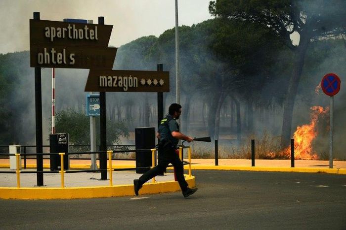 A Guardia Civil officer battling a wildfire near Mazagon in southwestern Spain, which has forced more than 2,000 people to evacuate the area