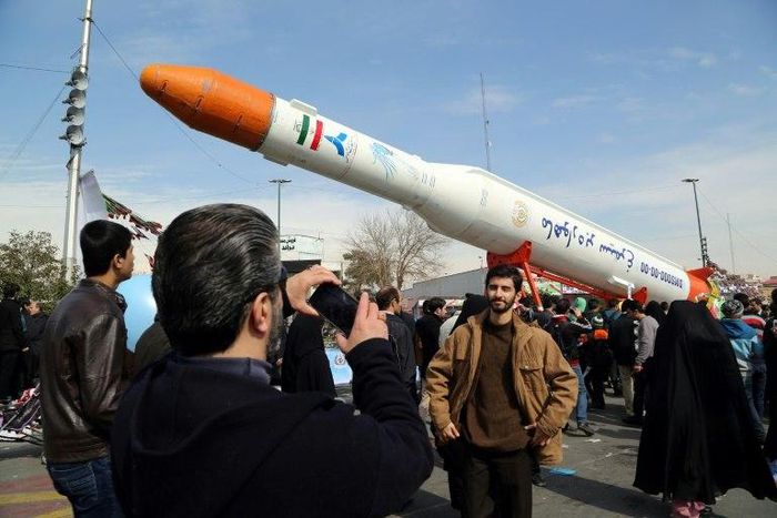 Iranians take pictures of the Simorgh satellite rocket during celebrations in Tehran to mark the 37th anniversary of the Islamic revolution on February 11, 2016