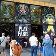 People stand in front the Paris-Saint-Germain football club store on the Champs Elysees avenue in Paris