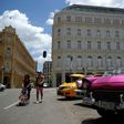 Cubans walk near the Manzana Kempinski Hotel, the first ultra luxury hotel in Cuba, on May 22, 2017