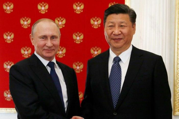 Russian President Vladimir Putin (left) shakes hands with China's President Xi Jinping during an informal meeting at the Kremlin on July 3, 2017