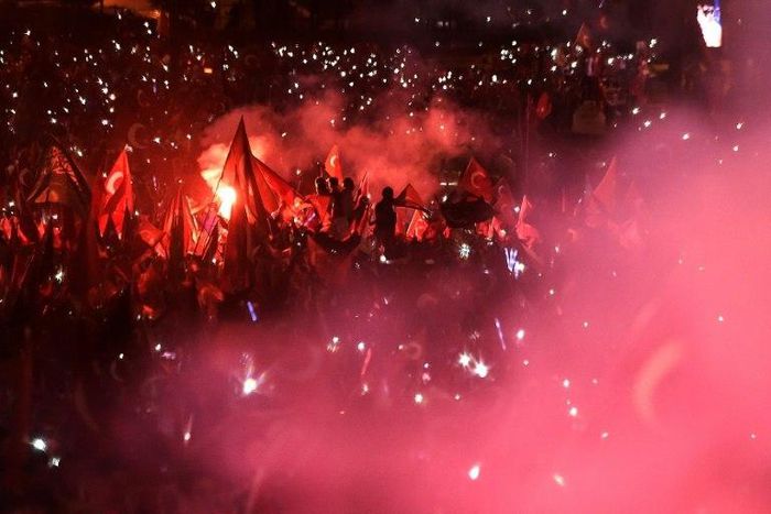 People wave Turkish national flags as Turkish President adresses a speech on July 15, 2017 during the first anniversary of failed coup in Istanbul